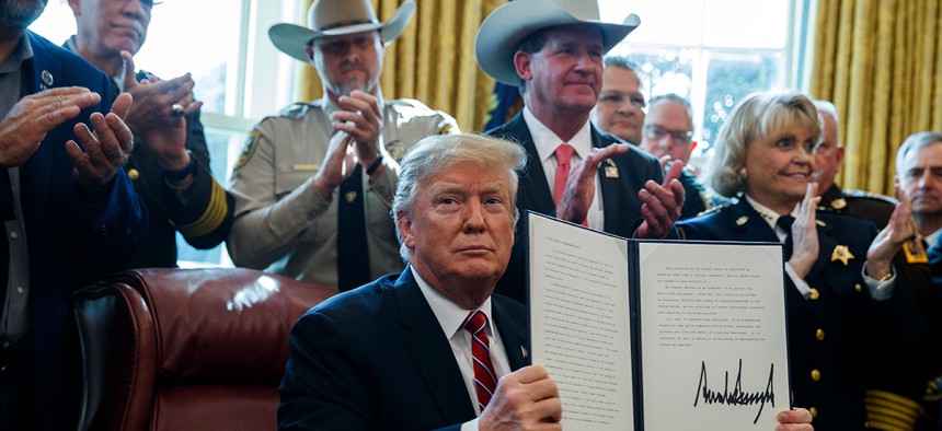 President Donald Trump signs the first veto of his presidency in the Oval Office of the White House on Friday.