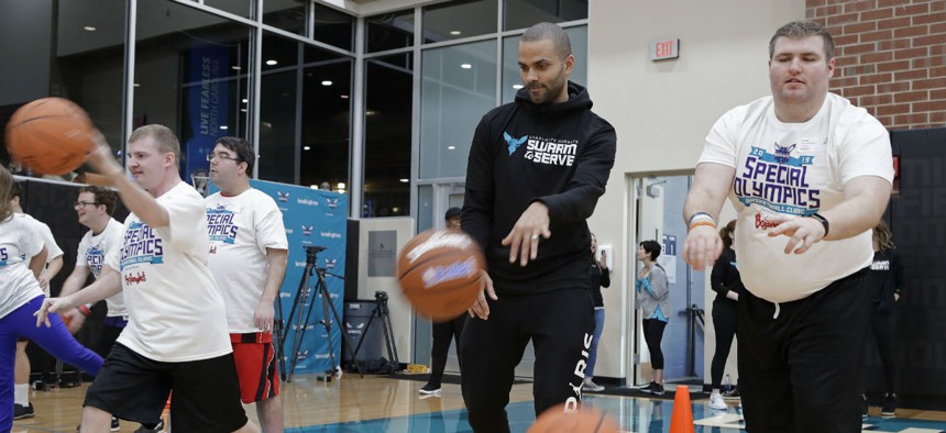 The Charlotte Hornets' Tony Parker, second from right, practices passing with athletes during a basketball clinic for Special Olympics athletes in January.