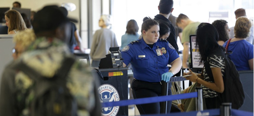 A TSA employee looks over passengers at a security checkpoint at LaGuardia Airport in New York.