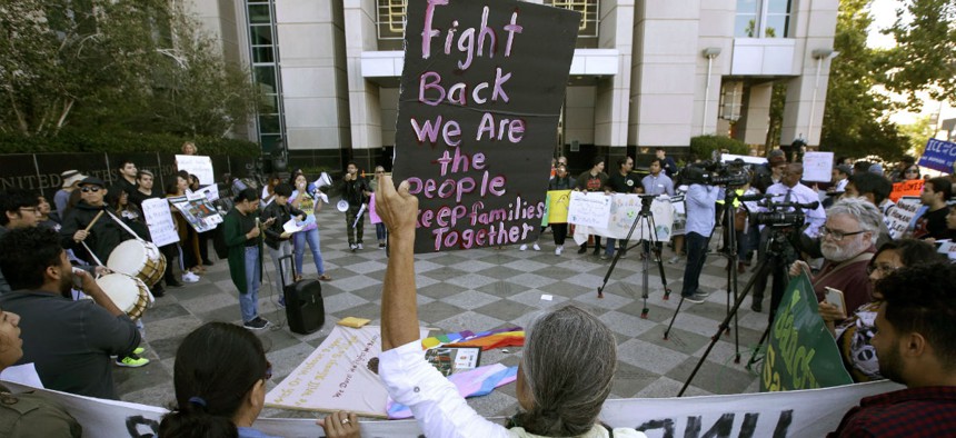 Protesters demonstrate outside the federal courthouse in Sacramento, Calif., in June 2018 where a judge heard arguments over the U.S. Justice Department's request to block three California laws that extend protections to people in the country illegally.