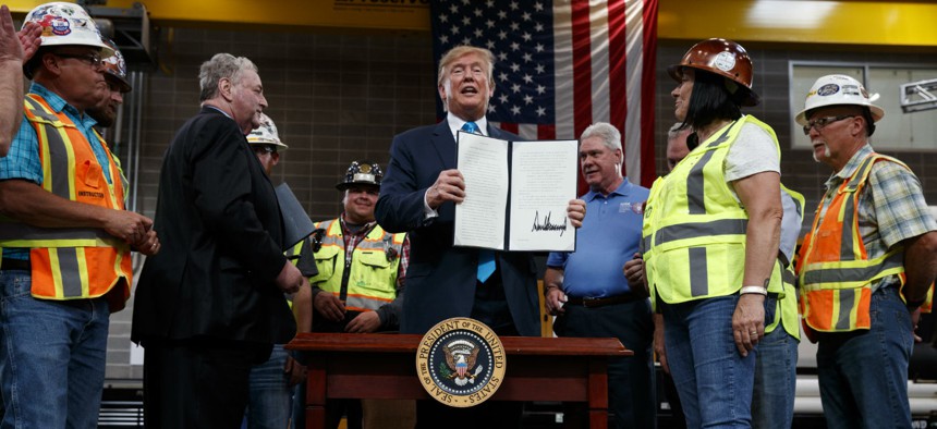 President Donald Trump holds up an executive order on energy and infrastructure after signing it at the International Union of Operating Engineers International Training and Education Center in Texas in April.