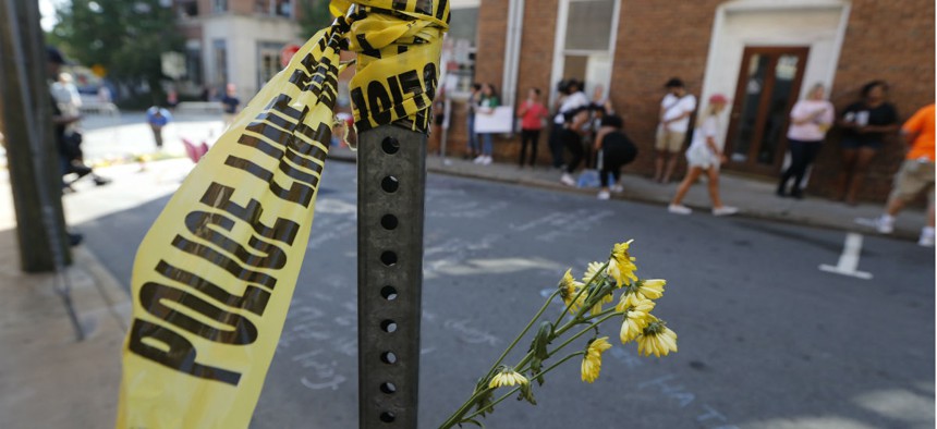 Police tape and flowers mark the site where a car plowed into a crowd of people protesting a white nationalist rally in August 2017 in Charlottesville, Va. 