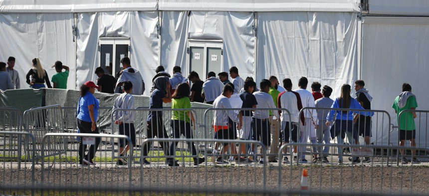 Children line up to enter a tent at the Homestead Temporary Shelter for Unaccompanied Children in Homestead, Fla., in February.