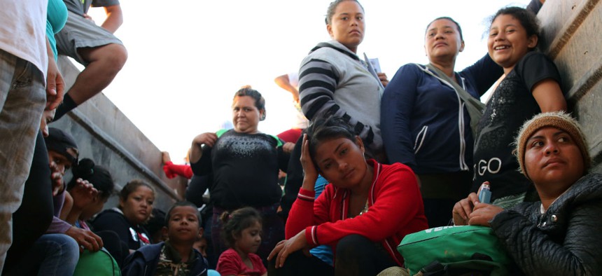 Honduran women and children fleeing poverty and gang violence in a caravan to the United States in November 2018 sit in a dump truck taking them to their next stop in Oaxaca, Mexico.