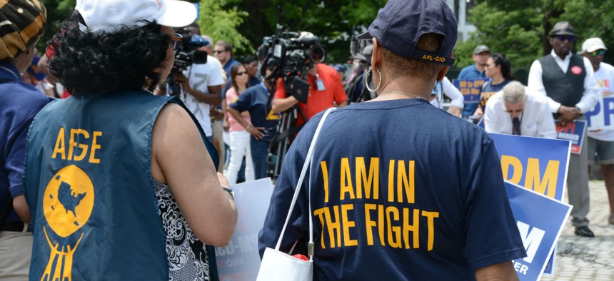 AFGE members in June protest a proposed merger of OPM and GSA.  Unions say the dues proposal would make it harder for them to represent federal workers. 