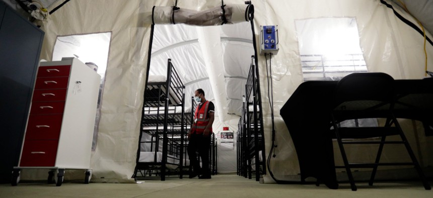 In this July 9, 2019, photo, a staff member works in the infirmary, a series of tents, at the U.S. government's newest holding center for migrant children in Carrizo Springs, Texas. 