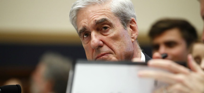 Former special counsel Robert Mueller, checks pages in the report as he testifies before the House Judiciary Committee hearing on his report on Russian election interference on Wednesday