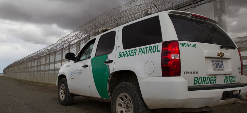 A Border Patrol vehicle sits along the border barrier separating San Diego and Tijuana in 2016.