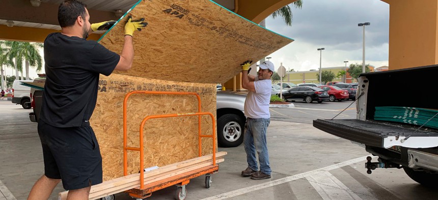 Shoppers in Pembroke Pines, Florida, buy plywood to board up windows before Dorian's landfall.