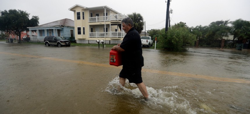 Angel Marshman carries a gas can as he walks through floodwaters from Tropical Depression Imelda to get to his flooded car, Wednesday, Sept. 18, 2019, in Galveston, Texas.