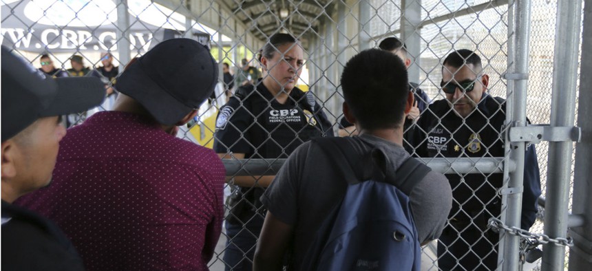 Migrants planning to seek asylum ask Customs and Border Protection officers when the border will re-open, after camping out on the Gateway International Bridge that connects downtown Matamoros, Mexico with Brownsville, Texas. 