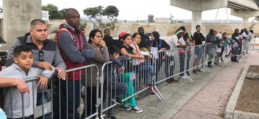 Asylum seekers in Tijuana, Mexico, listen to names being called from a waiting list to claim asylum at a border crossing in San Diego. 