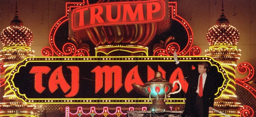 Donald Trump stands next to a genie lamp of his Trump Taj Mahal Casino Resort in 1990.