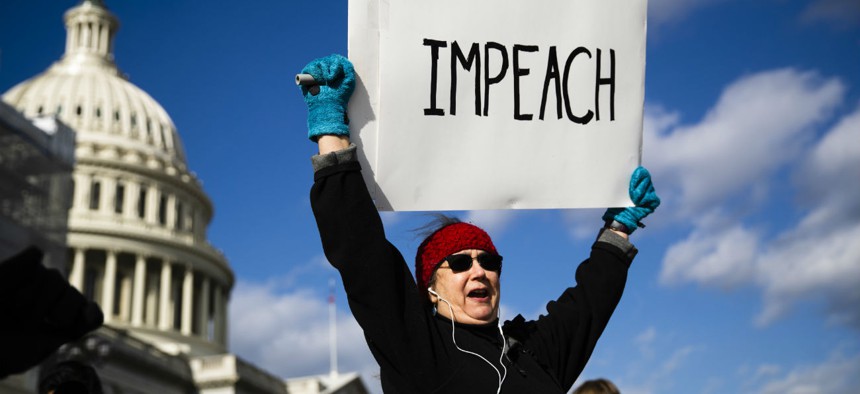 Protesters demonstrate as the House debates the articles of impeachment against President Trump on Wednesday.