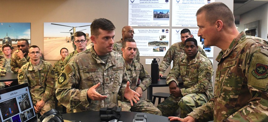 Capt. Alex Jessop, 821st Contingency Response Squadron, , shows a 3D printed adapter to a Phantom brand tactical airfield lights to Col. Douglas Jackson, 621st Contingency Response Wing commander, during Jackson's immersion tour June 24, 2019.
