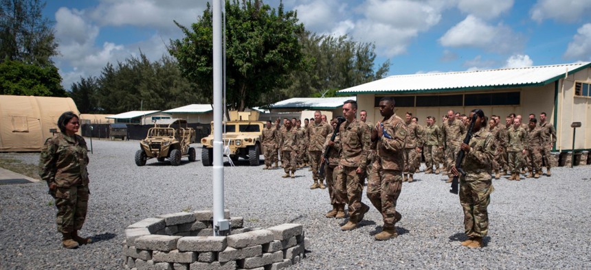 In this photo taken Aug. 26, 2019 and released by the U.S. Air Force, airmen from the 475th Expeditionary Air Base Squadron conduct a flag-raising ceremony, signifying the change from tactical to enduring operations, at Camp Simba, Manda Bay, Kenya.