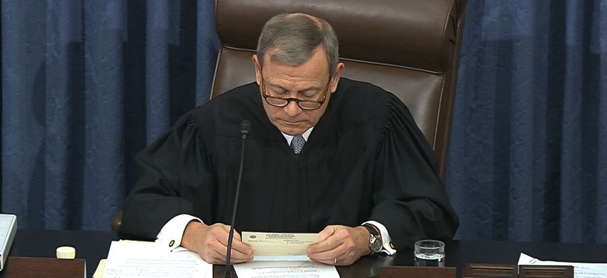 In this image from video, presiding officer Chief Justice of the United States John Roberts looks at a question submitted by Sen. Rand Paul, R-Ky., before declining to read it as written.