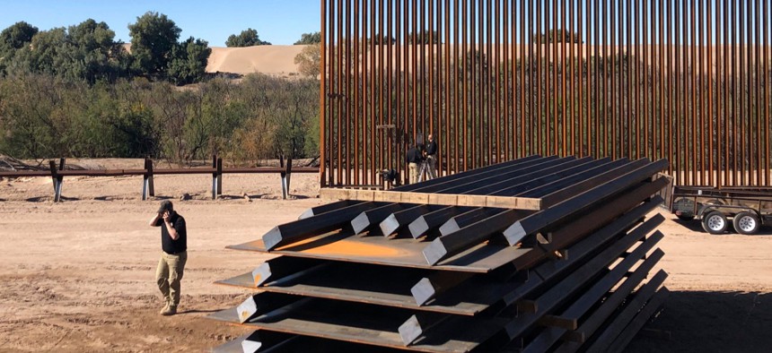 People work on a portion of border wall which was under construction in January in Yuma, Ariz.