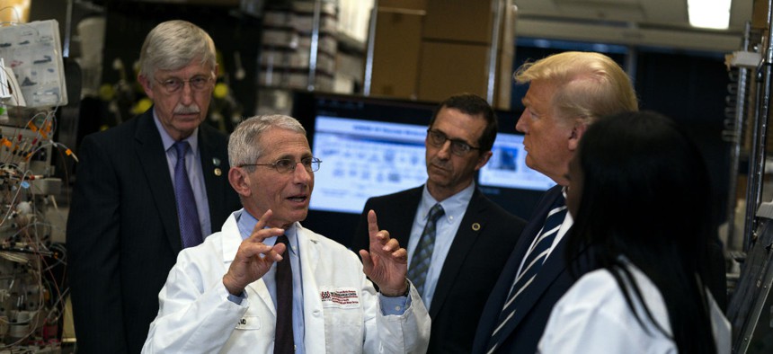 Dr. Anthony Fauci, director of the National Institute of Allergy and Infectious Diseases, talks with President Donald Trump during a tour of the Viral Pathogenesis Laboratory at the National Institutes of Health, Tuesday, March 3, 2020, in Bethesda, Md.