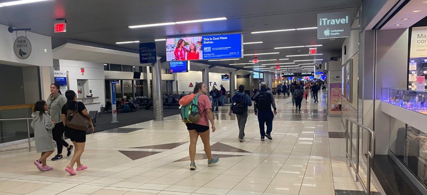 Travelers walk through the Hartsfield-Jackson Atlanta International Airport on Saturday, where flight cancellations and restrictions caused by the coronavirus outbreak left some passengers stranded. 