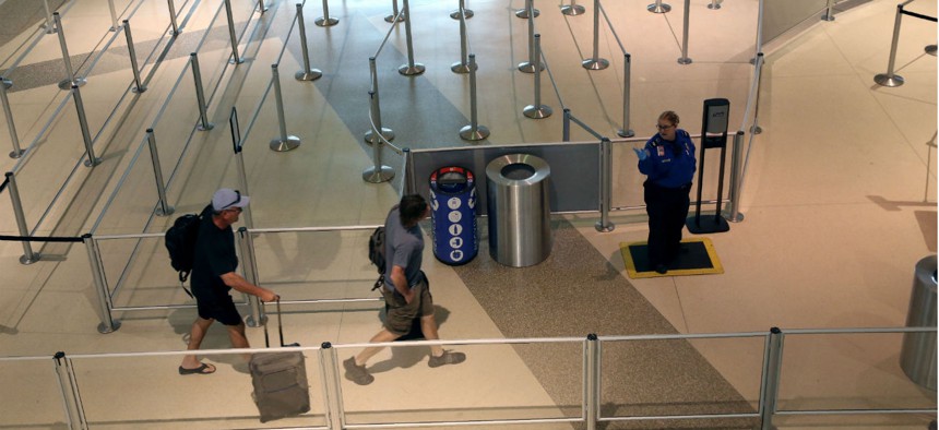A TSA agent speaks to travelers passing through an empty security queue at Love Field airport in Dallas on March 12.
