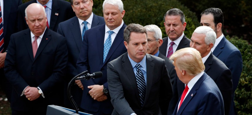 President Donald Trump shakes hands with Walmart CEO Doug McMillon at a White House press conference joining government and corporate officials – but no representatives of workers.