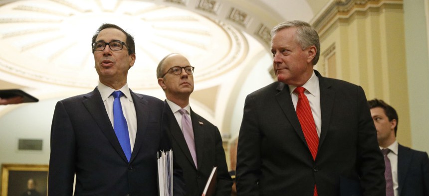 Treasury Secretary Steven Mnuchin, left, accompanied by White House Legislative Affairs Director Eric Ueland and acting White House chief of staff Mark Meadows meet with lawmakers Tuesday to discuss an economic stimulus package in response to coronavirus.