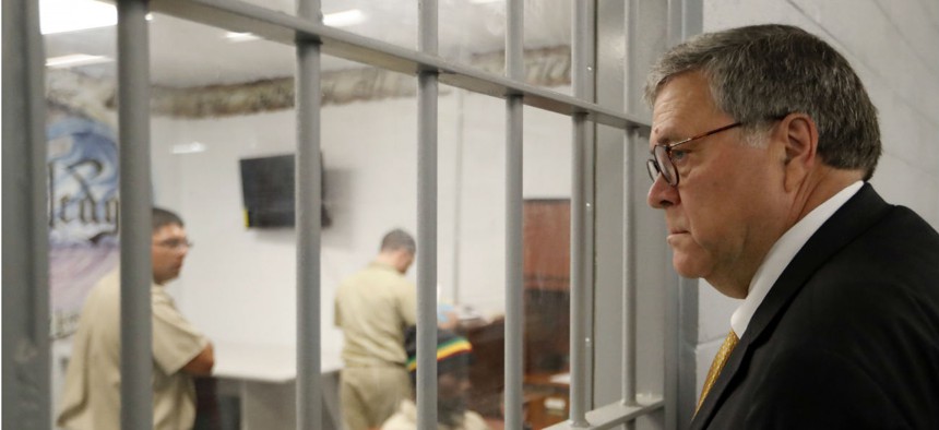 Attorney General William Barr watches as inmates work in a computer class during a tour of a federal prison in July 2019.