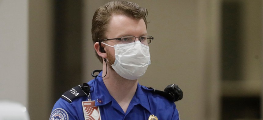 A TSA officer wears a mask at the Salt Lake City International Airport on Wednesday. TSA  told employees on Thursday that, for the first time, it will make N95 masks available to front-line employees. 