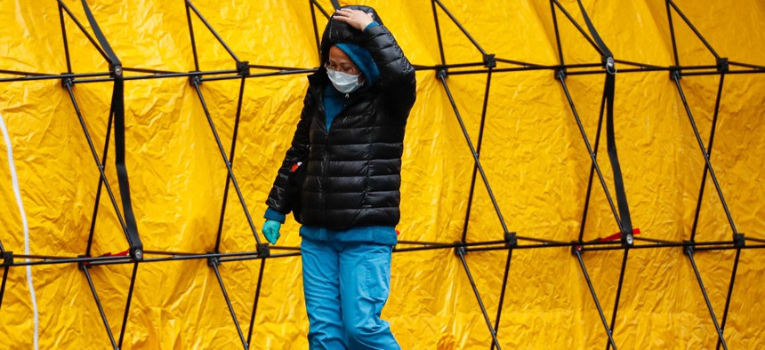 A medical worker walks past a COVID-19 testing tent tunnel set up outside the main entrance to the Department of Veterans Affairs Medical Center in New York. 