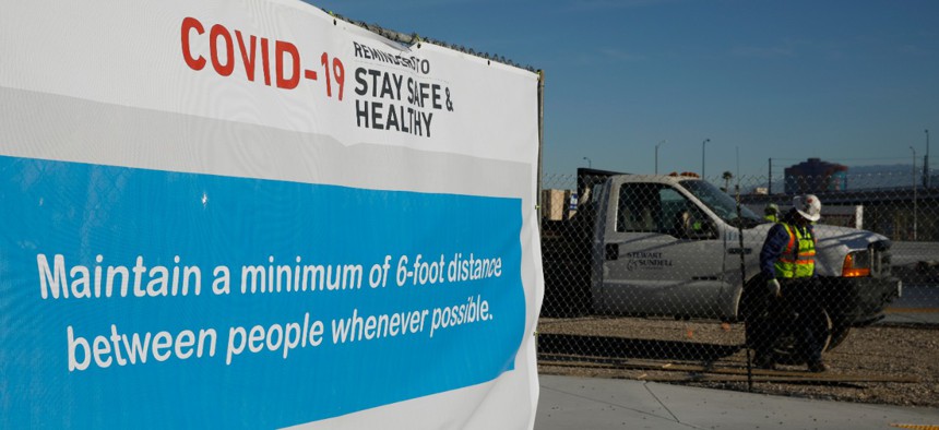 A sign gives guidelines for protection from COVID-19 as construction continues at Allegiant Stadium in Las Vegas on Tuesday.