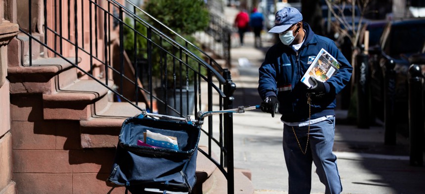 A mail carrier makes a delivery in Philadelphia on April 2. 