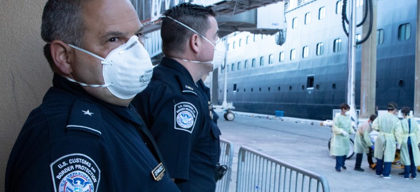 U.S. Customs and Border Protection officers wear personal protective equipment to guard against coronavirus as they facilitate the arrival of passengers and crew disembarking cruise ships at Port Everglades, Florida, on April 3.