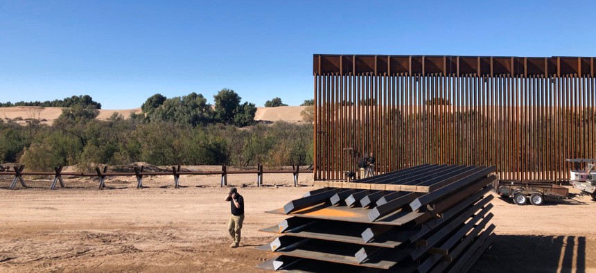 People work on a portion of border wall in Yuma, Ariz., in January. Construction on the wall has not stopped despite the pandemic. 
