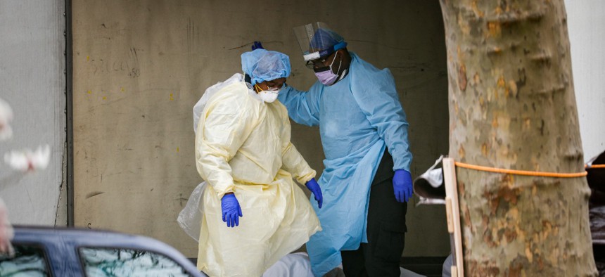 Medical workers step over bodies as they search a refrigerated trailer at Kingsbrook Jewish Medical Center on April 3 in Brooklyn, New York.