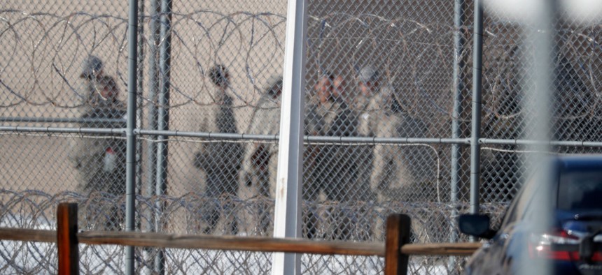 Prisoners stand outside of the federal correctional institution in Englewood, Colo., in February. 