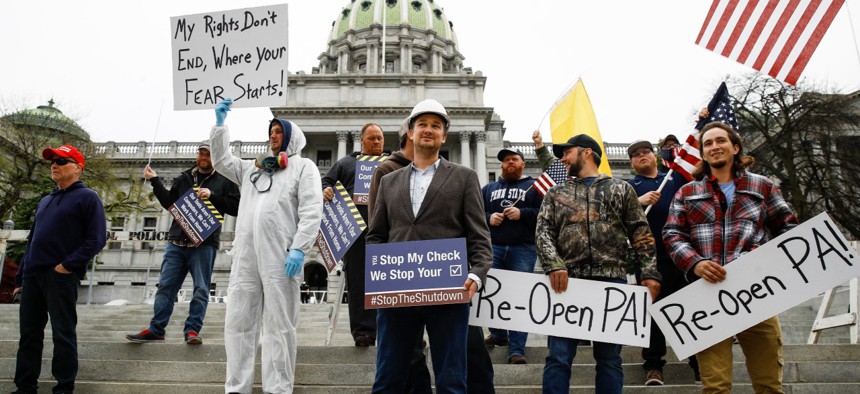 Protesters demonstrate at the state capitol in Harrisburg, Pa., on Monday demanding that Gov. Tom Wolf reopen Pennsylvania's economy even as new social-distancing mandates took effect at stores and other commercial buildings. 