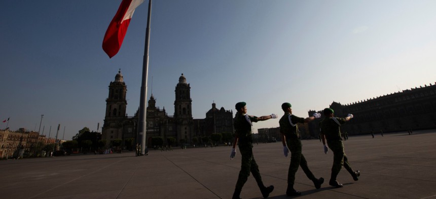 Mexican soldiers leave the Zocalo square after deploying the national flag in Mexico City in March. 