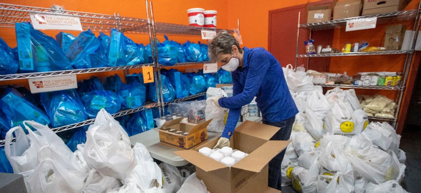 A volunteer prepares bags of groceries for delivery in Brooklyn. The pandemic has spurred tremendous need as well as a surge in volunteerism. Federal employees must ensure their activities remain within ethical boundaries, officials say.