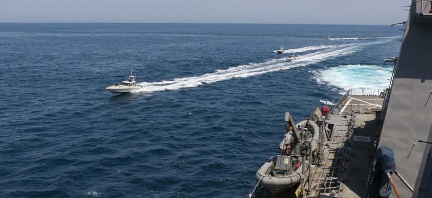 In this April 15 photo made available by U.S. Navy, Iranian Revolutionary Guard vessels sail close to U.S. military ships in the Persian Gulf near Kuwait.