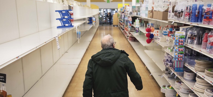 A shopper looks for toilet paper at a Stop & Shop supermarket during hours open daily only for seniors Thursday, March 19, 2020, in North Providence, R.I. 