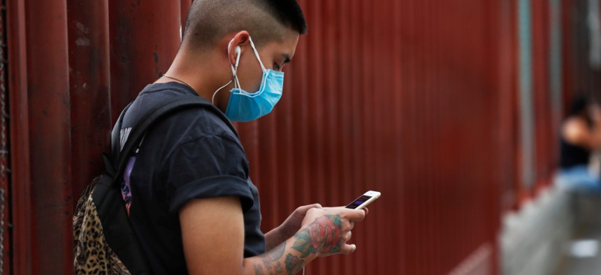 A man wearing a mask against the spread of the new coronavirus chats on his mobile phone outside a hospital in Iztapalapa, Mexico City, on April 30. 