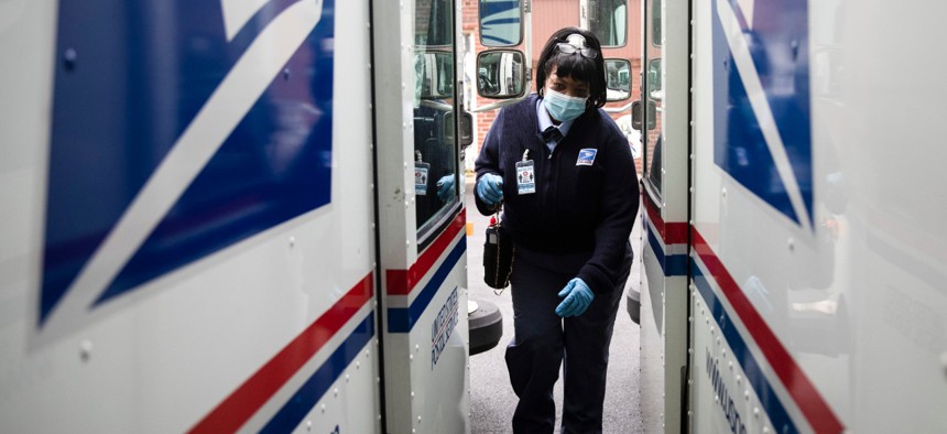 Postal Service carrier Henrietta Dixon gets into her truck to deliver mail in Philadelphia on May 6. Sixty U.S. Postal Service employees have died from the novel coronavirus. 