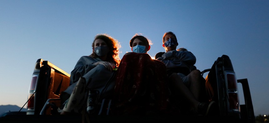 Moviegoers wear masks while watching a movie from a truck bed at Mission Tiki drive-in theater in Montclair, Calif., on May 28, 2020. 