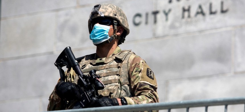 A member of California National Guard stands outside the City Hall on May 31 in Los Angeles. 