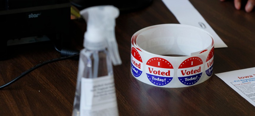 Stickers for voters in Iowa's Primary Election sit on a table next to a bottle of sanitizer at the Polk County Central Senior Center on June 2 in Des Moines, Iowa. The primaries will be a test for the Postal Service as many states expand vote-by-mail.