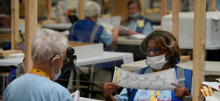 Election workers process mail-in ballots during a nearly all-mail primary election on Tuesday, June 9, 2020, in Las Vegas.