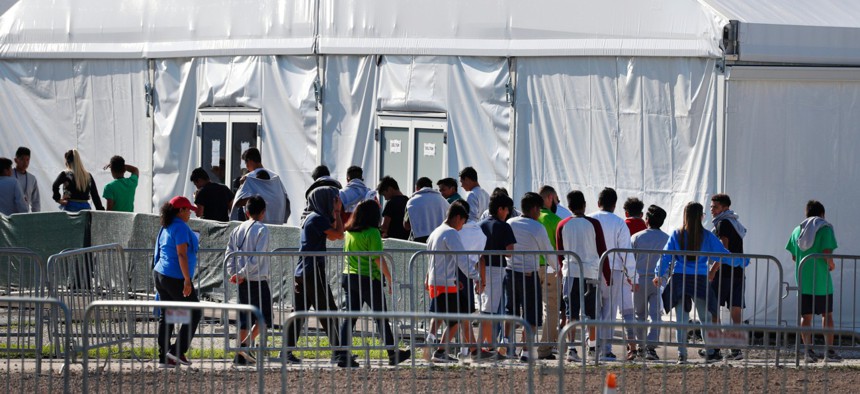 Children line up to enter a tent at the Homestead Temporary Shelter for Unaccompanied Children in Homestead, Fla., in 2019. 