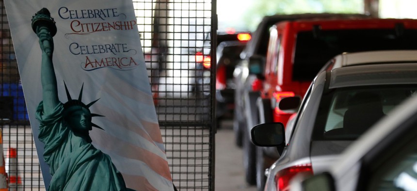 Cars line up during a drive-thru naturalization service in a parking structure at the USCIS headquarters on Detroit's east side. The ceremony is a way to continue working as the federal courthouse is shut down due to coronavirus. 