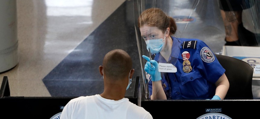 A Transportation Security Administration officer, right, talks with a passenger at a security checkpoint in O'Hare International Airport on June 16.